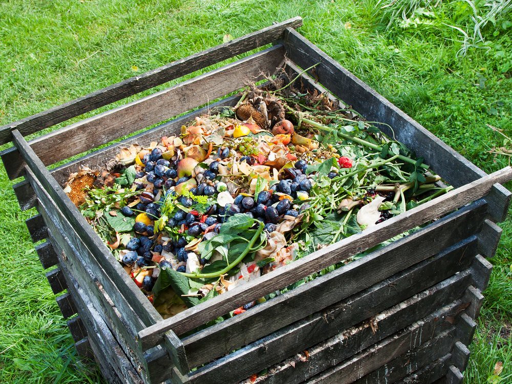 Photo shows a wooden compost container full of food scraps